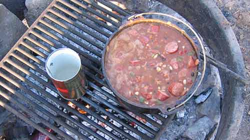 Cooking a pot of chili over the campfire